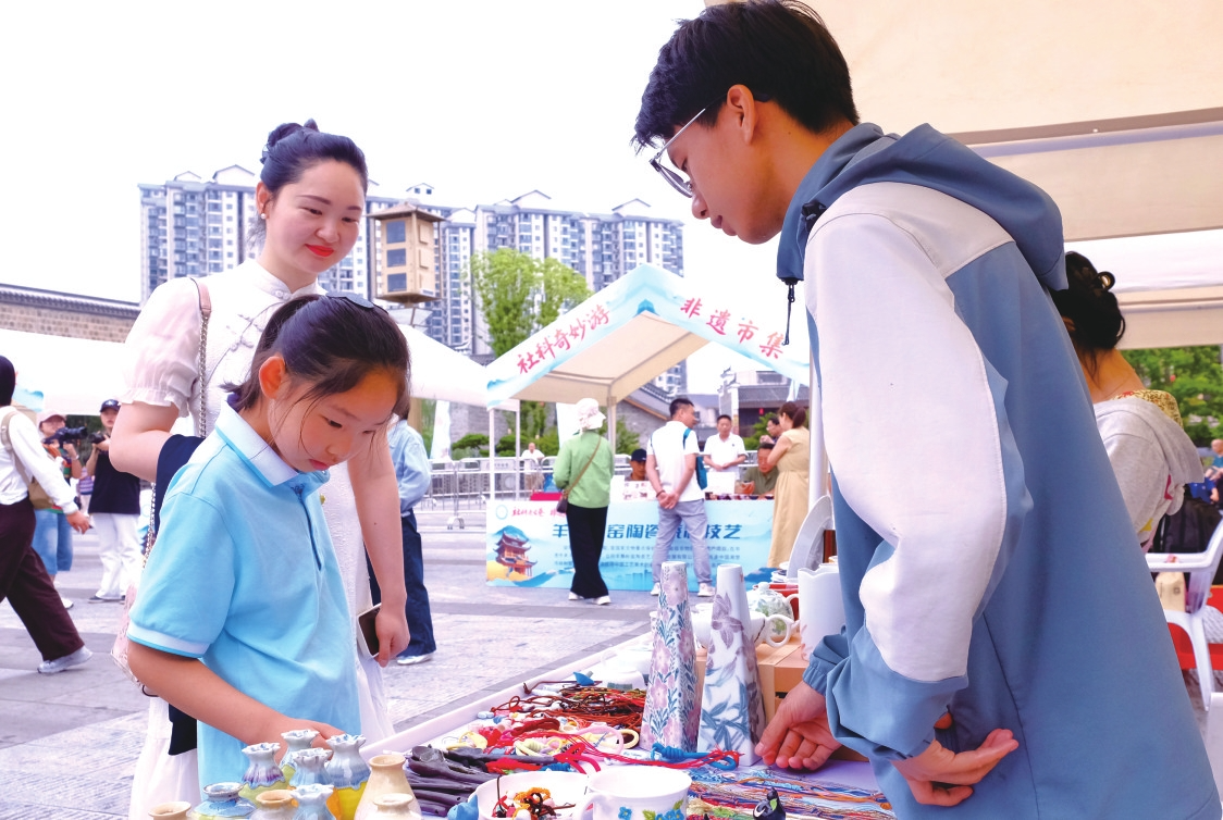 非遗集市上,孩子被展品吸引。